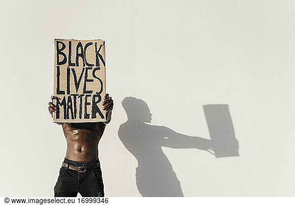 Mann hält Black Lives Matter-Schild vor sein Gesicht