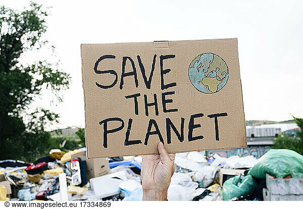 Mann hält Text zur Rettung des Planeten auf Karton