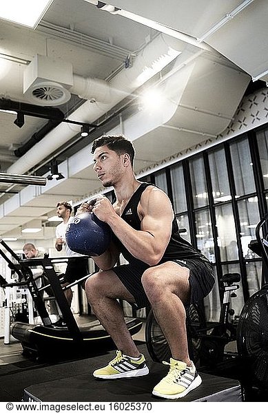 Mann im Fitnessstudio hebt Kettlebell