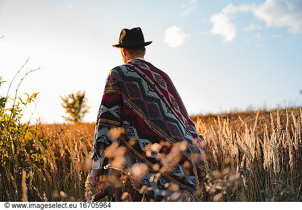Mann im Poncho auf einem Feld  stimmungsvolle ländliche Szene