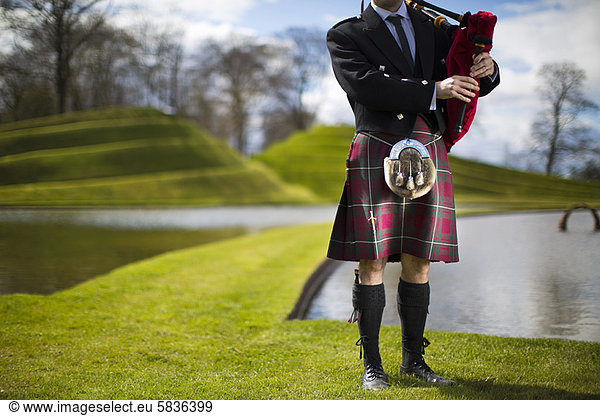 Mann im schottischen Kilt beim Dudelsackspielen