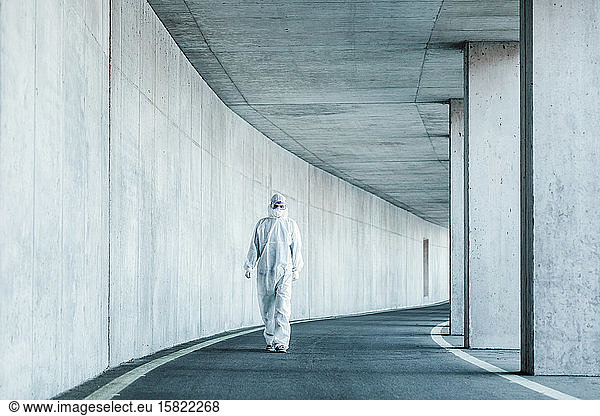 Mann in Schutzkleidung geht in einem Tunnel