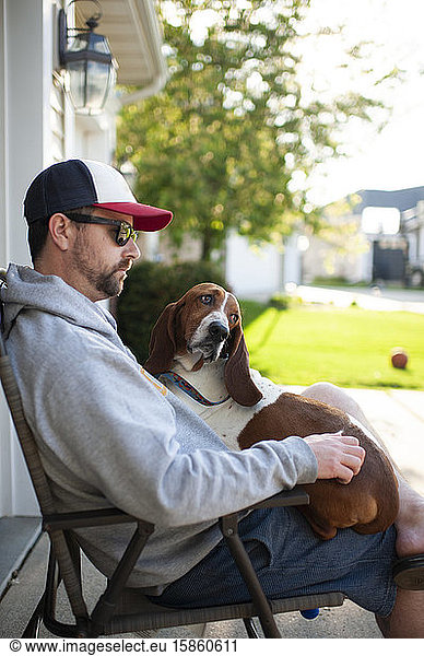 Mann 30-40 Jahre alt  auf einem Stuhl sitzend mit einem Dachshund auf dem Schoß