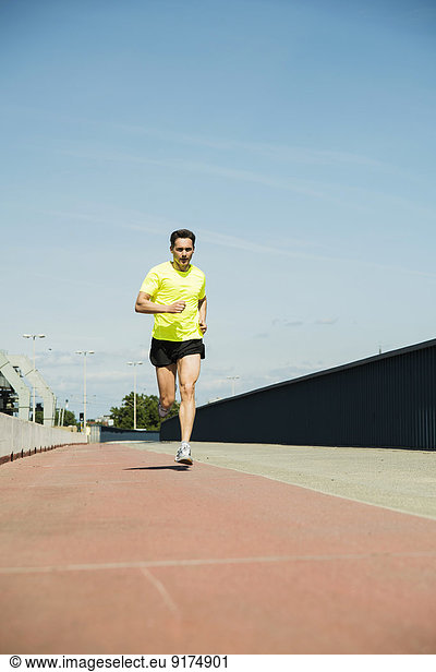 Mann joggt auf der Brücke