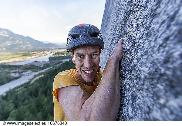 Mann kämpft beim Klettern im Vorstieg am Granit von Squamish mit der Weite