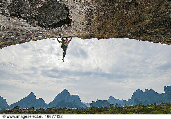 Mann klettert auf steilen Überhang in Yangshuo / China
