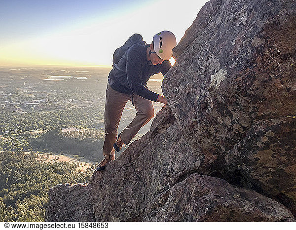 Mann klettert kurz nach Sonnenaufgang Freesolo auf steilen Grat