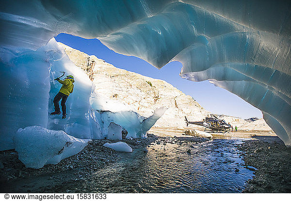 Mann klettert während einer Abenteuer-Hubschraubertour auf Gletschereis