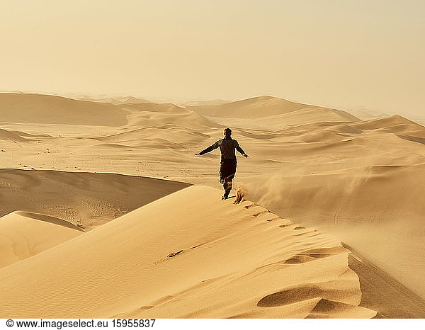 Mann läuft auf einer Düne in der Wüste  Düne 7  Walvis Bay  Namibia