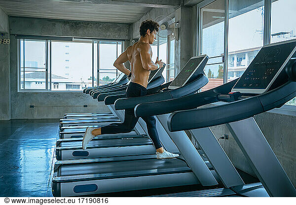 Mann läuft in Maschine Laufband im Fitnessstudio,  Sport,  Fitness,  E