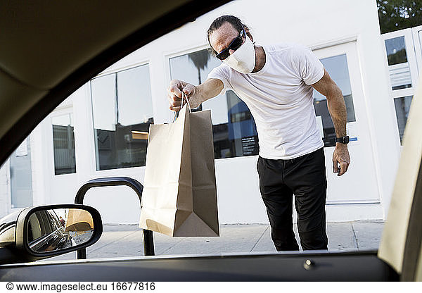 Mann liefert Tasche an Autofenster