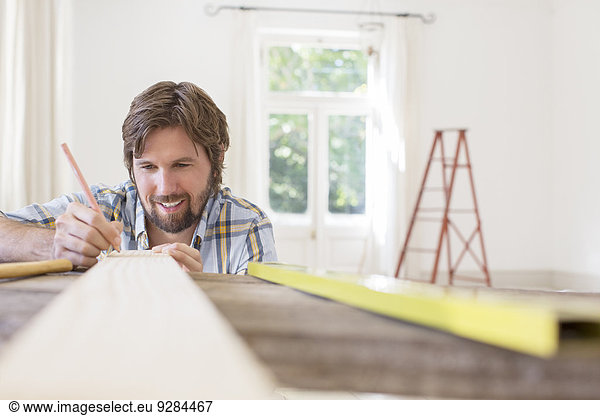 Mann markiert Holz im Wohnbereich