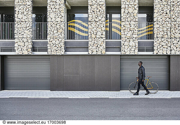 Mann mit Fahrrad auf dem Bürgersteig
