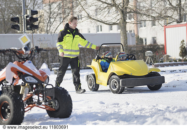 Mann mit Jungen fährt elektrisches Spielzeugauto