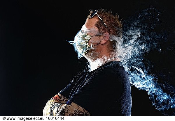 Mann mit Mundschutz raucht Zigarette  Corona Serie  Deutschland  Europa