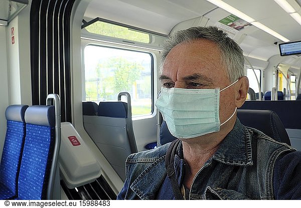 Mann mit Mundschutzmaske in der S-Bahn  Coronakrise  München  Bayern  Deutschland  Europa