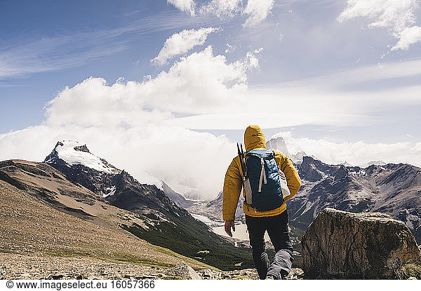 Mann mit Rucksack  der im Winter auf einem Berg gegen den Himmel läuft  Patagonien  Argentinien