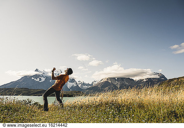 Mann mit Siegergeste in der Nähe des Pehoe-Sees im Torres Del Paine National Park  Chile Patagonien  Südamerika