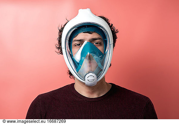 Mann mit Unterwassermaske  Covid-19 Schutz  farbiger Hintergrund