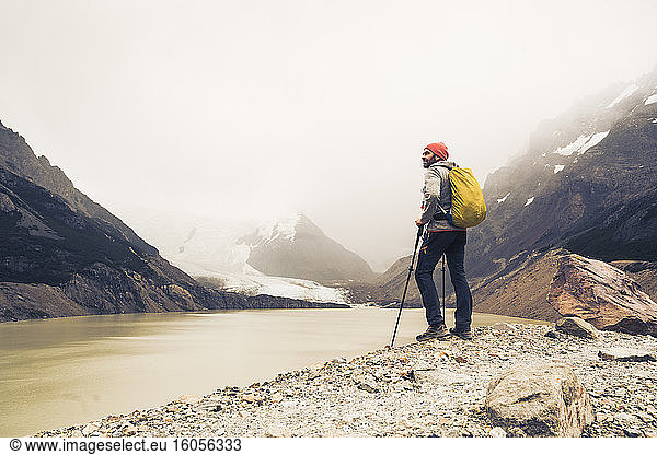 Mann mit Wanderstöcken steht am See gegen den Himmel in Patagonien Argentinien