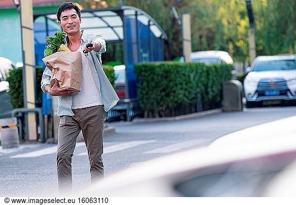 Mann mittleren Alters hält eine Einkaufstasche