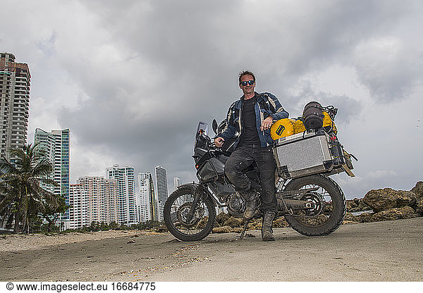 Mann posiert nach einer langen Reise neben seinem Abenteuer-Motorrad  Kolumbien