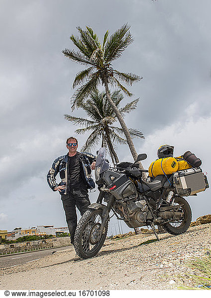 Mann posiert nach einer langen Reise neben seinem Abenteuer-Motorrad  Kolumbien