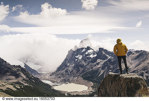 Mann schaut auf einen schneebedeckten Berg vor bewölktem Himmel  Patagonien  Argentinien