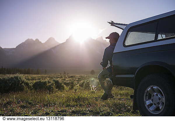 Mann schaut weg während er auf einem Geländewagen im Grand-Teton-Nationalpark sitzt