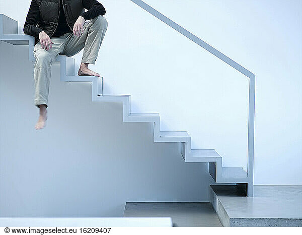 Mann sitzt auf einer Treppe
