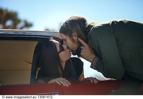 Mann sitzt im Auto und küsst Mann