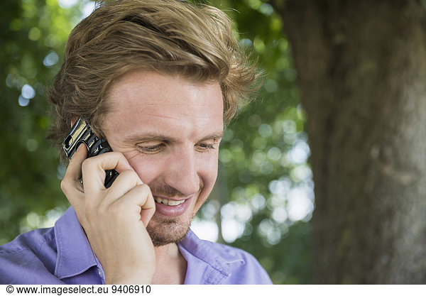 Mann sprechen lächeln Mittelpunkt Smartphone Erwachsener