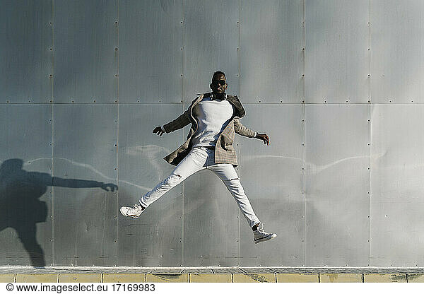 Mann springt durch Metallwand