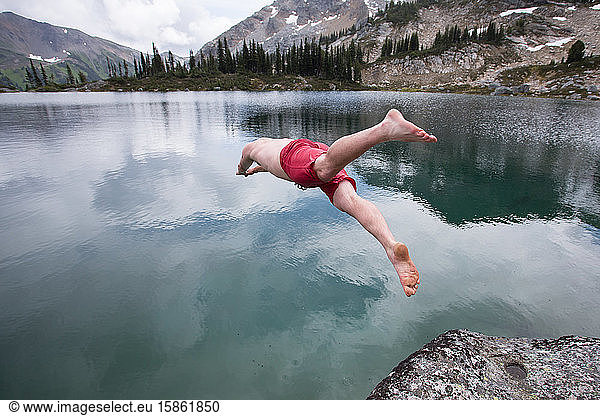 Mann springt in Alpensee