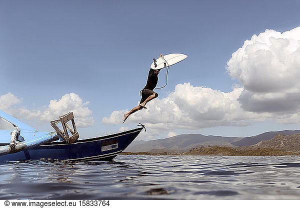 Mann springt vom Boot ins Meer