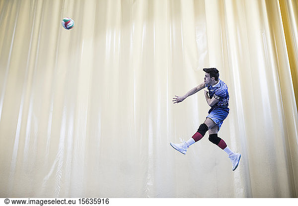 Mann springt während eines Volleyballspiels  um ein Spiel zu beginnen