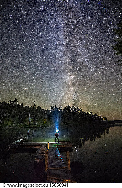Mann starrt mit einem Scheinwerfer auf die Milchstraße