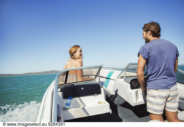 Mann steuert Boot mit Freundin