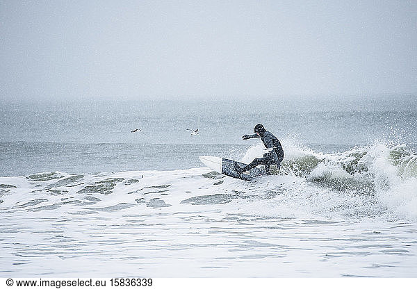Mann surft im Winterschnee