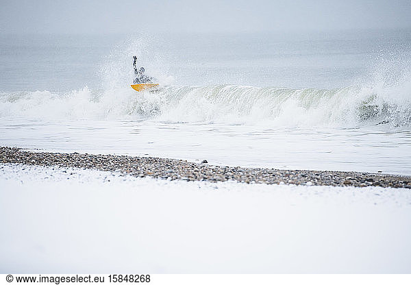 Mann surft im Winterschnee