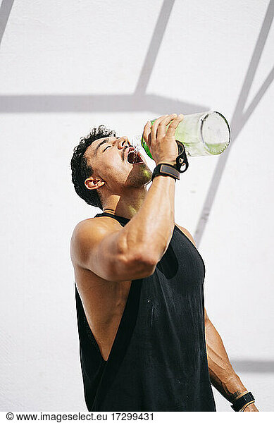 Mann trinkt Wasser nach dem Training