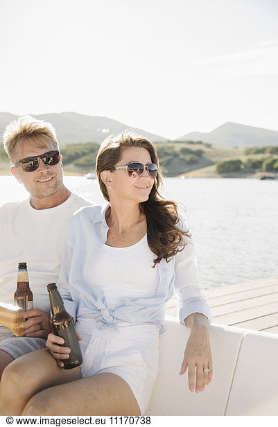Mann und Frau auf einem Segelboot  bei einem Drink.