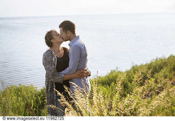 Mann und Frau küssen sich am Meer
