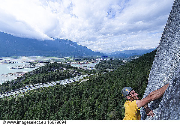 Mann unscharf Vordergrund Klettern mit Squamish Stadt Wald Hintergrund