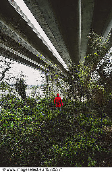 Mann unter einer Autobahnbrücke in verlassener Umgebung