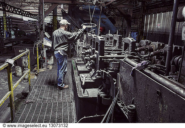 Mann untersucht Maschinen in Fabrik