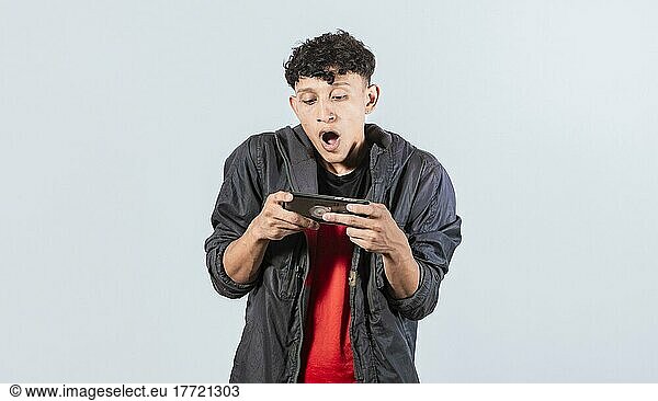 Mann verblüfft hält Handy horizontal  Guy keuchend und spielen Spiele auf seinem Smartphone