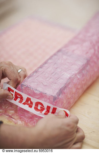 Mans Hands Wrapping Fragile Goods