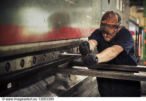 Manual worker using t wrench in metal industry