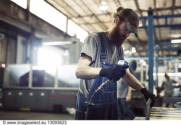 Manual worker using welding machine in industry